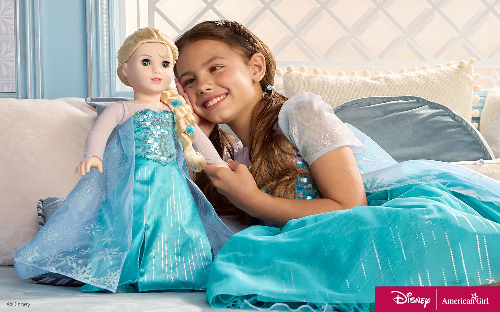 Girl and Elsa doll sitting on couch