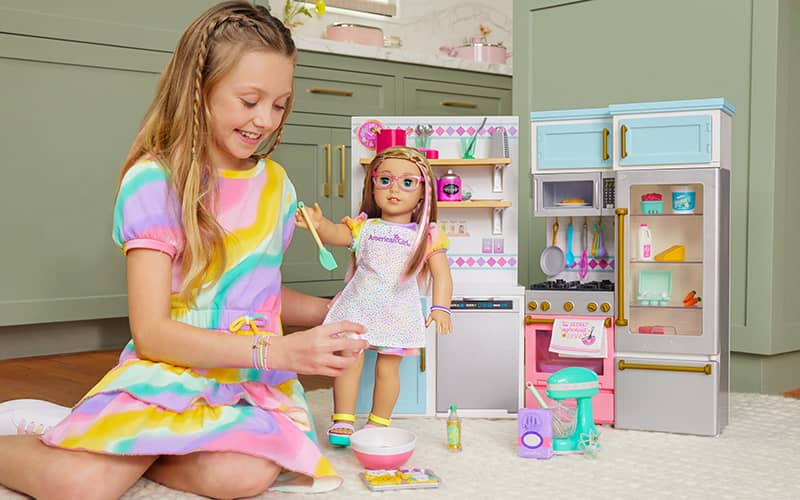 Girl playing with her doll in the Gourmet Kitchen set