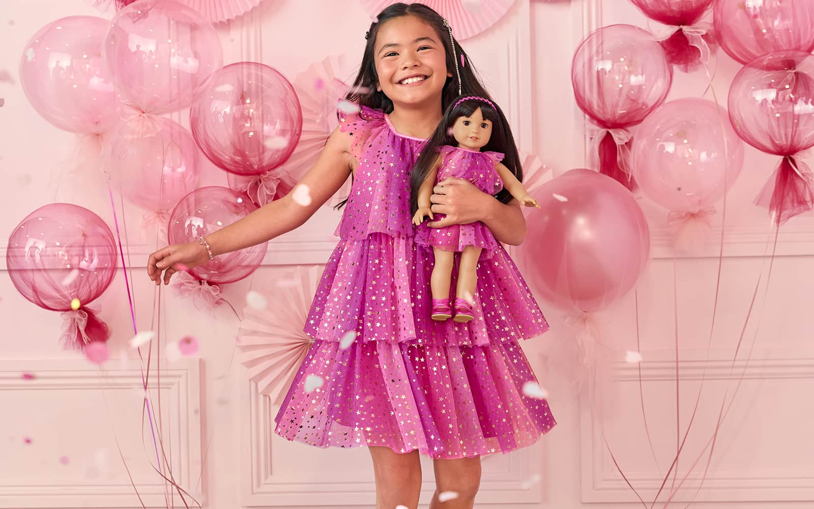 Girl in matching pink dress with her doll