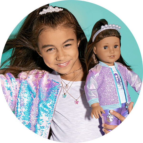 Girl in matching sequin outfit with doll