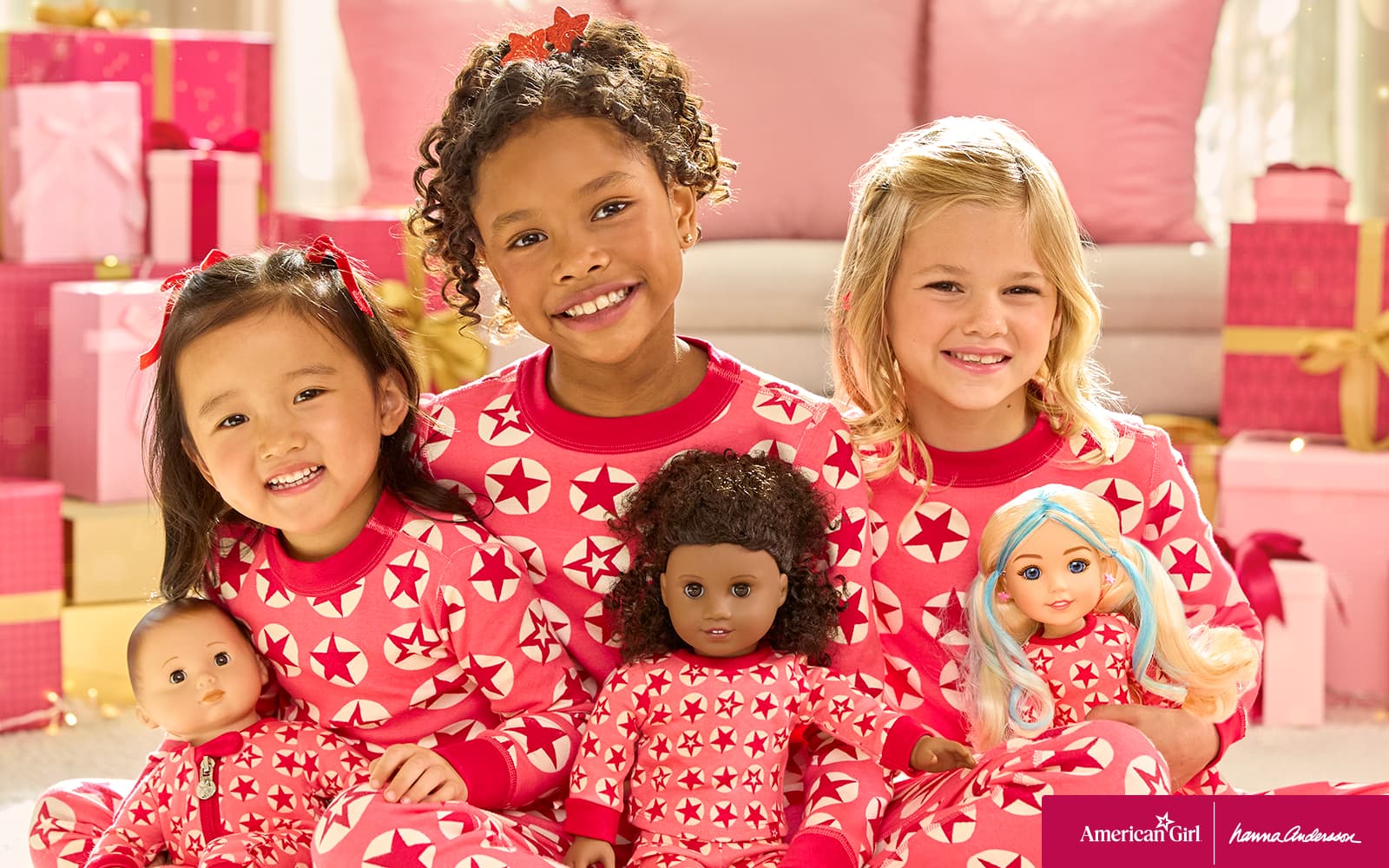 Three girls in matching Hanna Andersson pajamas with their dolls