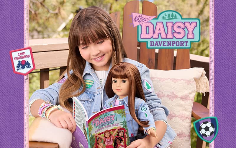 Girl reading Daisy Davenport Saves the Day with doll on her