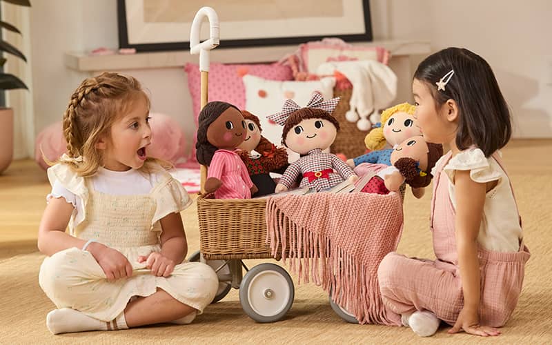 Two little girls with wagon filled with the first American Girl collection