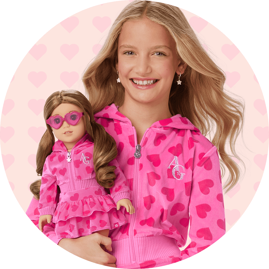 Young girl and doll in a matching pink set