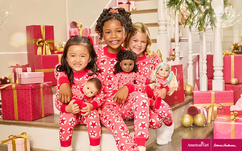 Girls in matching Hanna Andersson pajamas with dolls