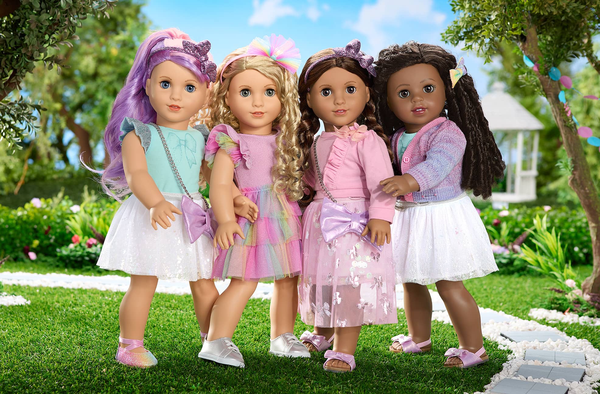 Four Truly Me dolls standing while wearing spring dresses