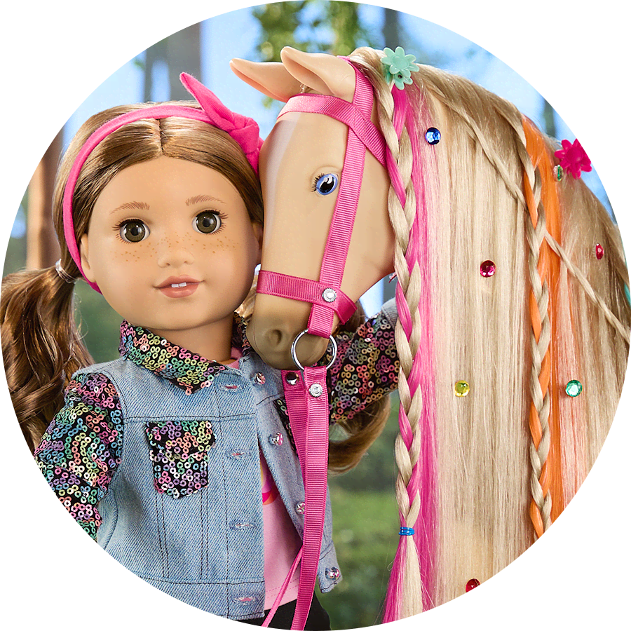 Doll in pigtails standing next to toy horse with pink and orange braids