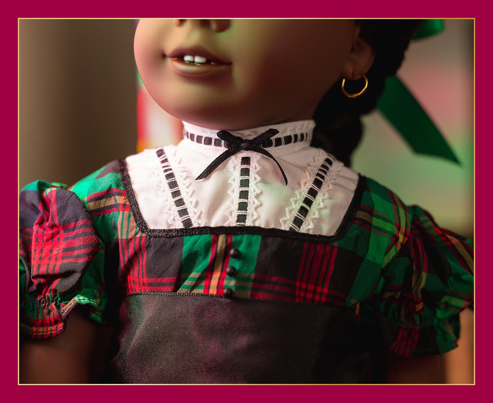 Close up of Addy festive tartan dress with white yoke, short puffed sleeves and sash