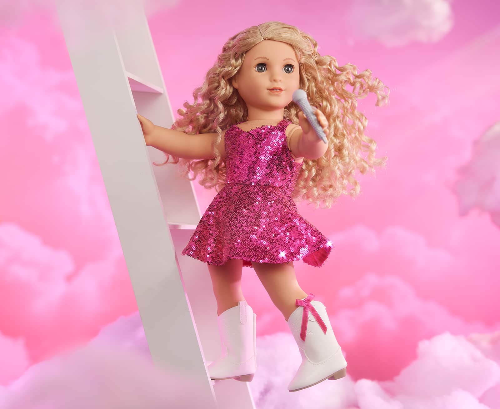 Doll in stage outfit on ladder with pink cloud background
