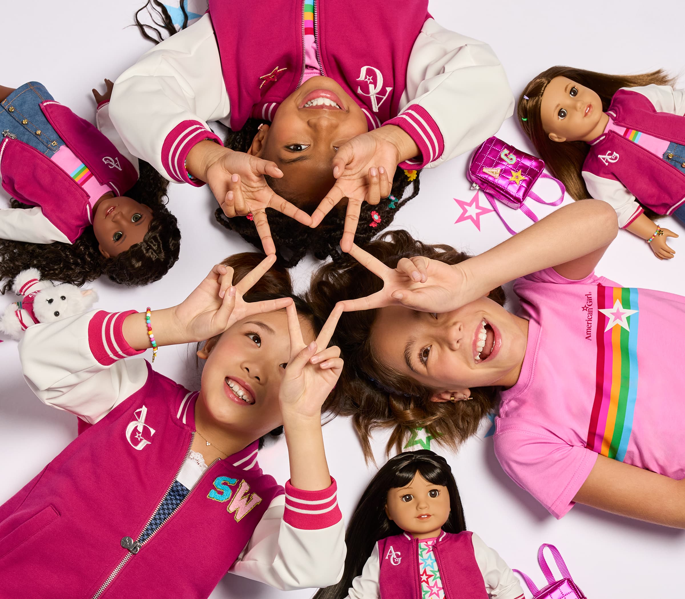 Girls and their dolls holding their fingers in a star formation
