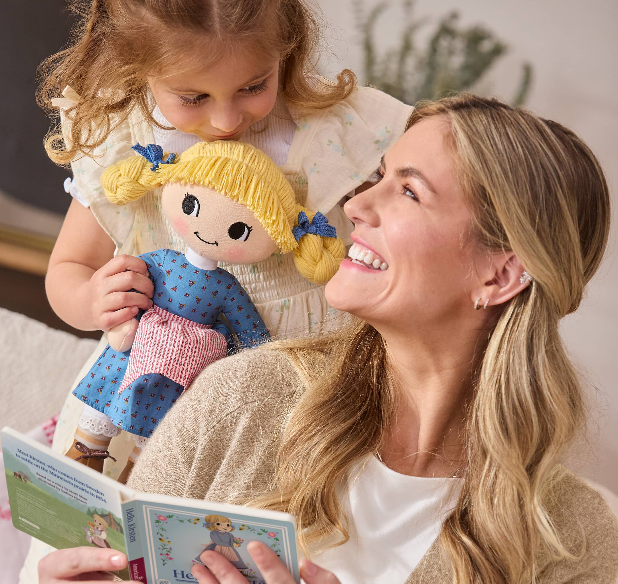Girl holding Kirsten Larson plush doll