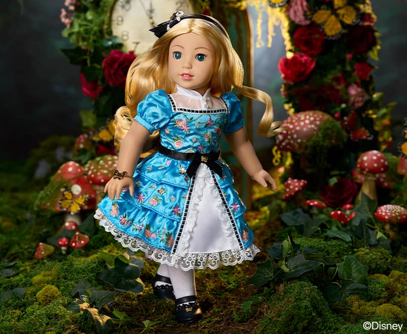 Alice doll standing with clock and mushroom in the background